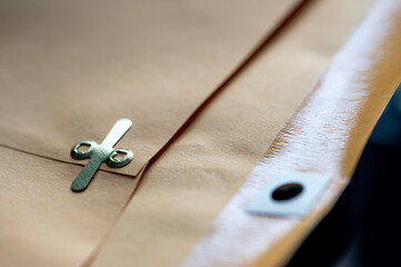 manilla envelope with reinforced hole and metal folding clasp.