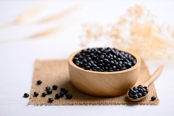 Fototapeta na wymiar Black soybean seeds in bowl with spoon, food ingredients high protein good for vegetarian and vegan