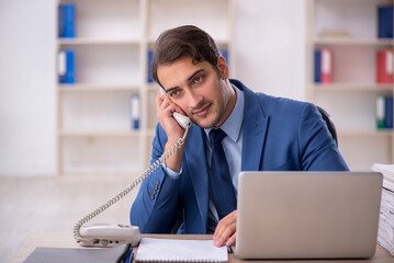 Young male employee and too much work in the office