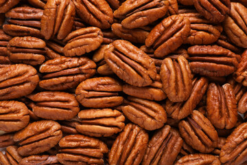 Tasty fresh ripe pecan nuts as background, top view