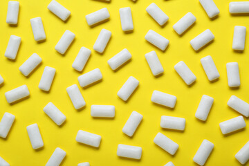 Fototapeta na wymiar Tasty white chewing gums on yellow background, flat lay