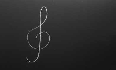 Treble clef drawn with chalk on blackboard. Music Concept.