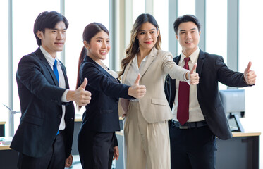 Millennial Asian young professional successful male female businessmen businesswomen in formal suit standing smiling side by side smiling showing thumbs up together in company office workstation