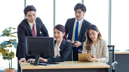 Millennial Asian young professional successful  businesswoman in formal suit with female and male businessman colleague in formal suit brainstorming  in company office room.