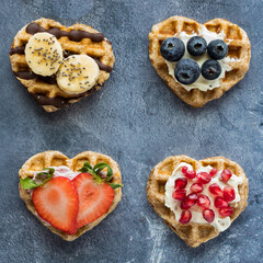 Heart shaped mini waffles topped with various spreads and fruit.