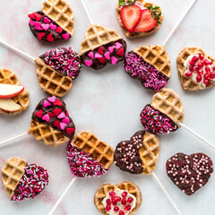 Decorated heart shaped waffle pops in a circle with copy space in the middle