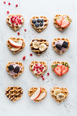 Heart shaped mini waffles with various toppings of spreads and fresh fruit.