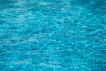 Background of blue water in swimming pool with sun reflection, ripple water wave in pool. Clear water background.