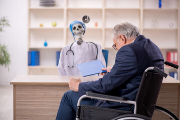 Old patient in wheel-chair visiting devil doctor