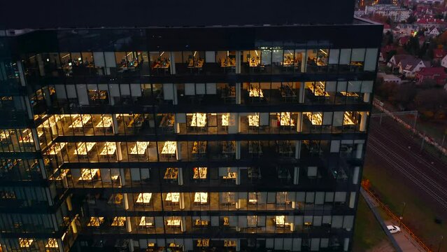 Aerial view of office windows of skyscrapers at night, International Business Center, Gdansk. Young creative people, businessmen, work at computers until late at night. Close-up of fifis windows