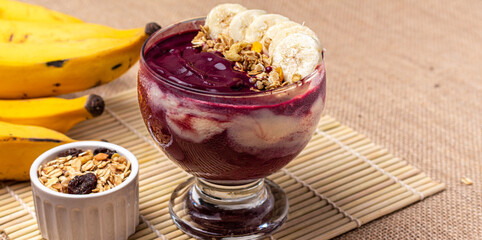 Acai bowl with banana and granola isolated on white background.	