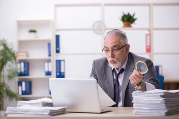 Old male auditor working in the office