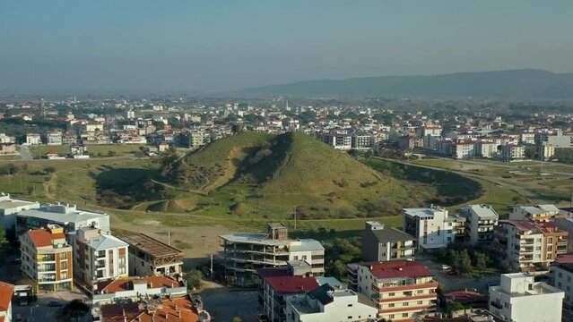 A drone view of Yığmatepe, the largest tumulus in Bergama and its historical features, and the houses around it.