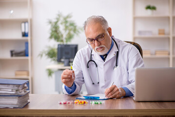 Old male doctor pharmacist in drugs synthesis concept