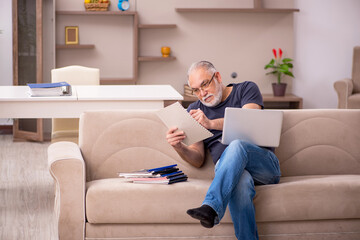 Obraz premium Old male employee working from home during pandemic