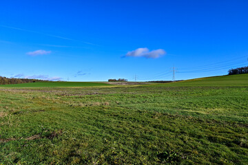 Panorama über Felder und eine Stromtrasse mit Wald bei Sommerhausen im Winter bei blauem Himmel, Franken, Bayern, Deutschland