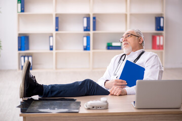 Old male doctor working in the clinic