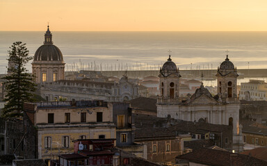 Fototapeta premium Cupola of Saint Agath cathedral and bell towers of Saint Francis of Assisi in front of the Mediterranean Sea, Baroque monuments in Catania city, Sicily, Italy at sunrise, aerial view