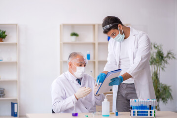 Two male chemist working at the lab