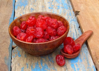 Dried cherry in a bowl on wooden background