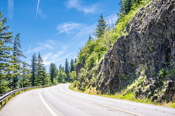 Winding mountain road goes around a stone cliff in the picturesque Columbia Gorge National...