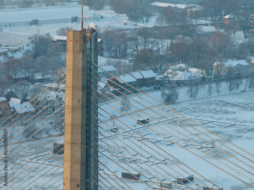 Poster a view of a bridge in the snow from a high viewpoint of a city with houses and trees in the backgrou