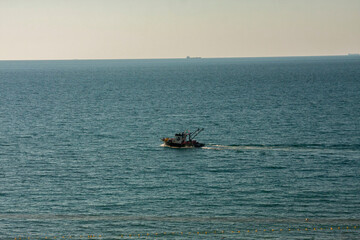 Small fishing boat in the Black Sea, View of small fishing boat on a sunny day, Seascape, Leisure activity, concept photo.