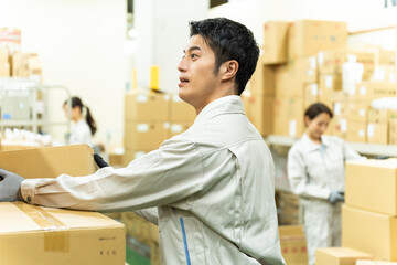 倉庫で作業する若い日本人男女