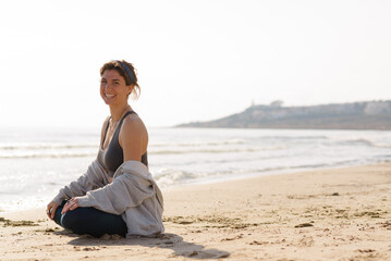 Fototapeta na wymiar young woman does yoga on the beach
