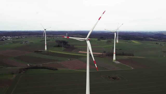 Critical Energy Production: Rotating Windmills on a Field in Sauerland, Germany, Aerial backwards