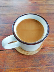A cup of coffee placed on the wooden table