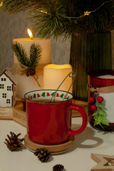 Red New Year's Christmas cup on the background of a bouquet of Christmas tree branches