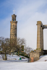 Obraz premium Calton Hill , Nelson Monument and Cityscape view of Edinburgh old town numerous attractions around during winter snow at Edinburgh , Scotland : 28 February 2018
