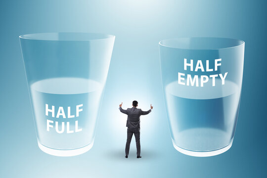 Businessman in half empty half full glass concept