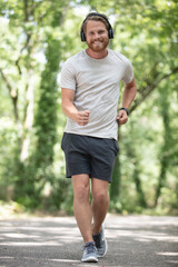 man wearing headphones is fast walking