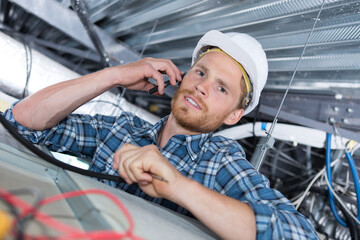 tradesman in roof space using cellphone