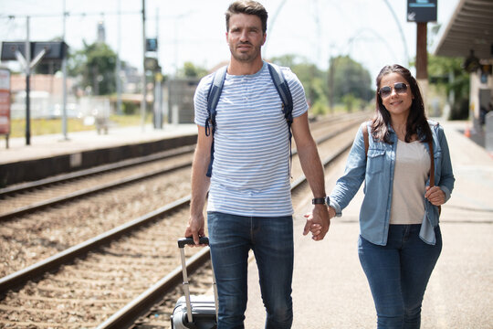 loving couple tourist holding hand at train station