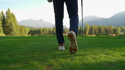 Golfer walking in green golf course in the rocky mountains of Banff and Kananaskis of Alberta, Canada