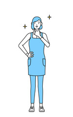 自信家のポーズを取るエプロンを着た女性