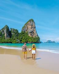 Railay Beach Krabi Thailand, the tropical beach of Railay Krabi, a couple of men and women on the beach, Panoramic view of idyllic Railay Beach in Thailand with a traditional long boat. © Fokke Baarssen