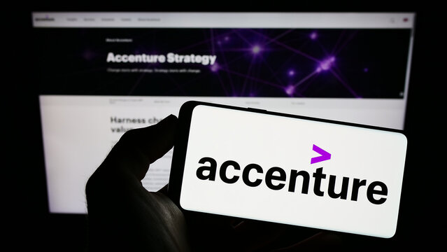 Stuttgart, Germany - 12-23-2022: Person holding smartphone with logo of information technology company Accenture plc on screen in front of website. Focus on phone display.