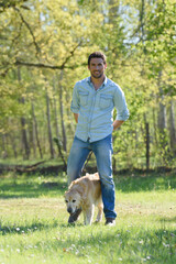man hiking in autumn forest with dog