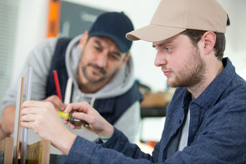 two engineers discussing plans with cmm arm in foreground