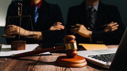 Business and lawyers discussing contract papers with brass scale on desk in office. Law, legal services, advice, justice and law concept picture with film grain effect