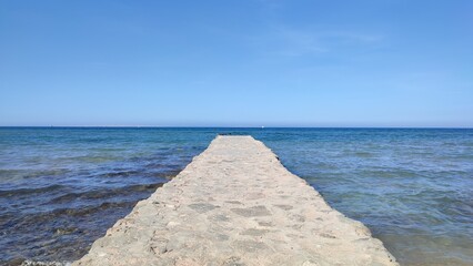 stone jetty pier with the ocean horizon in the background