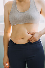 Beautiful fat woman with tape measure She uses her hand to squeeze the excess fat that is isolated on a white background. She wants to lose weight, the concept of surgery and break down fat under the