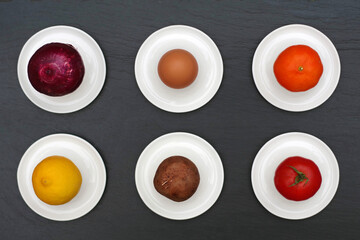 Various foods on white porcelain egg cup plates