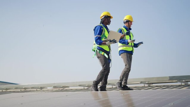 Engineer on rooftop walking next to solar panels photo voltaic check alignment for good installation