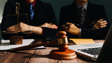 Business and lawyers discussing contract papers with brass scale on desk in office. Law, legal services, advice, justice and law concept picture with film grain effect