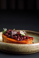Grilled beef tongue served with fresh berries over black background